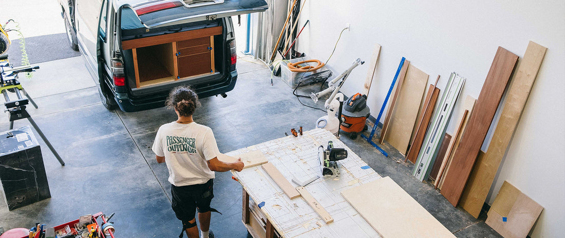 A man stood in his workshop, with a campervan